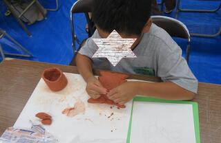参加者が粘土で埴輪を作っている様子