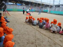 園庭に並んで待ち、教えてもらったことを先生が模擬道路を