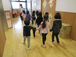 各クラスが作った手作りのお店を異年齢で一緒に遊びます。5歳児がリードして3歳、4歳と3人組になり廊下を移動しています。