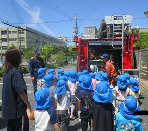 こどもたちが、消防士の方に消防車について質問をしています。