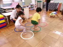 リングを両足で跳ぶ2歳児。