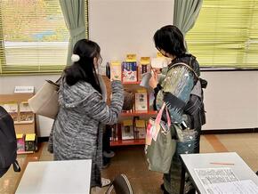 中央に本を並べたブックトラックがあり、参加者数名が本を見ている様子