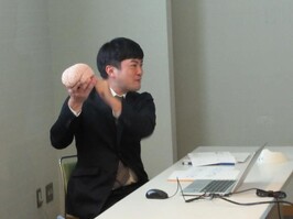 脳の模型を持つ講師