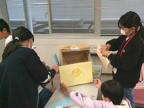 ダンボールやペットボトルを使用して、ガチャガチャを作る様子