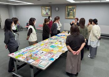 性教育の本を見る受講生と説明する講師の様子